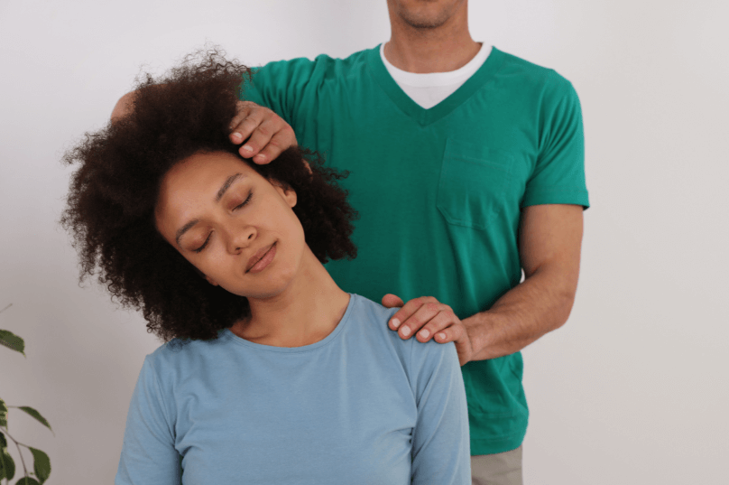 An associate chiropractor assisting a patient with their back in a modern and well-established clinic.