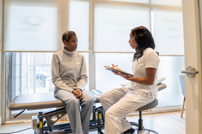 A chiropractic student intern learning from an experienced chiropractor in a clinic.